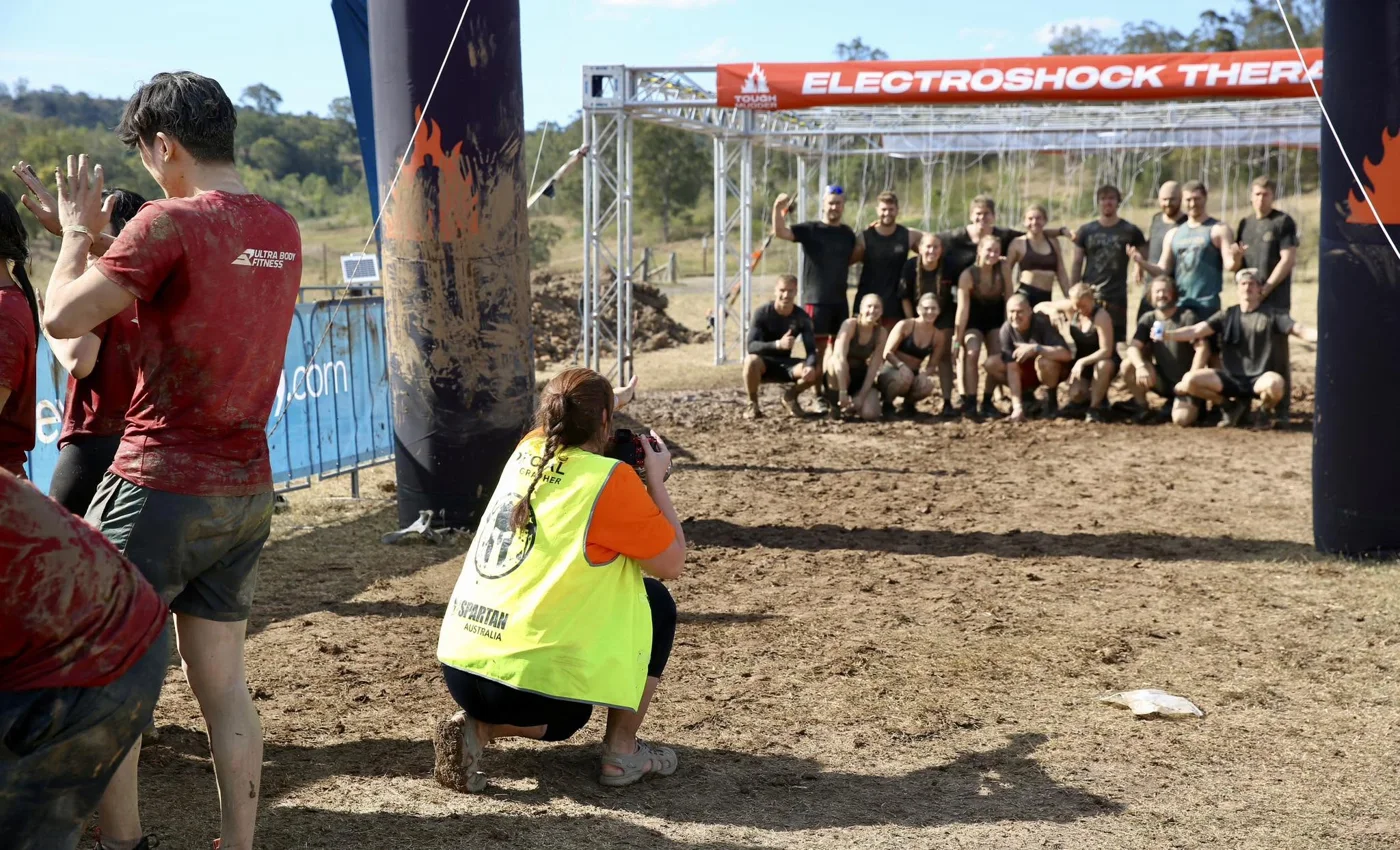 Photographing a team at the finish line at Tough Mudder.